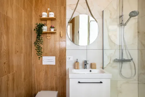 Baño con ducha, lavamanos y enchapes.