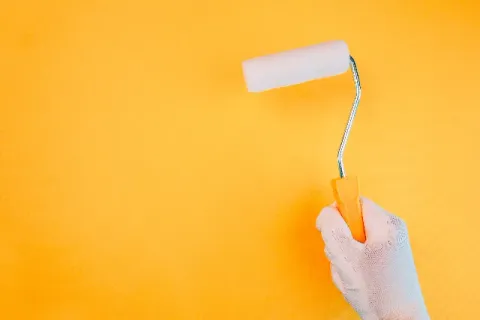 Aplicación de pintura con rodillo sobre un muro.